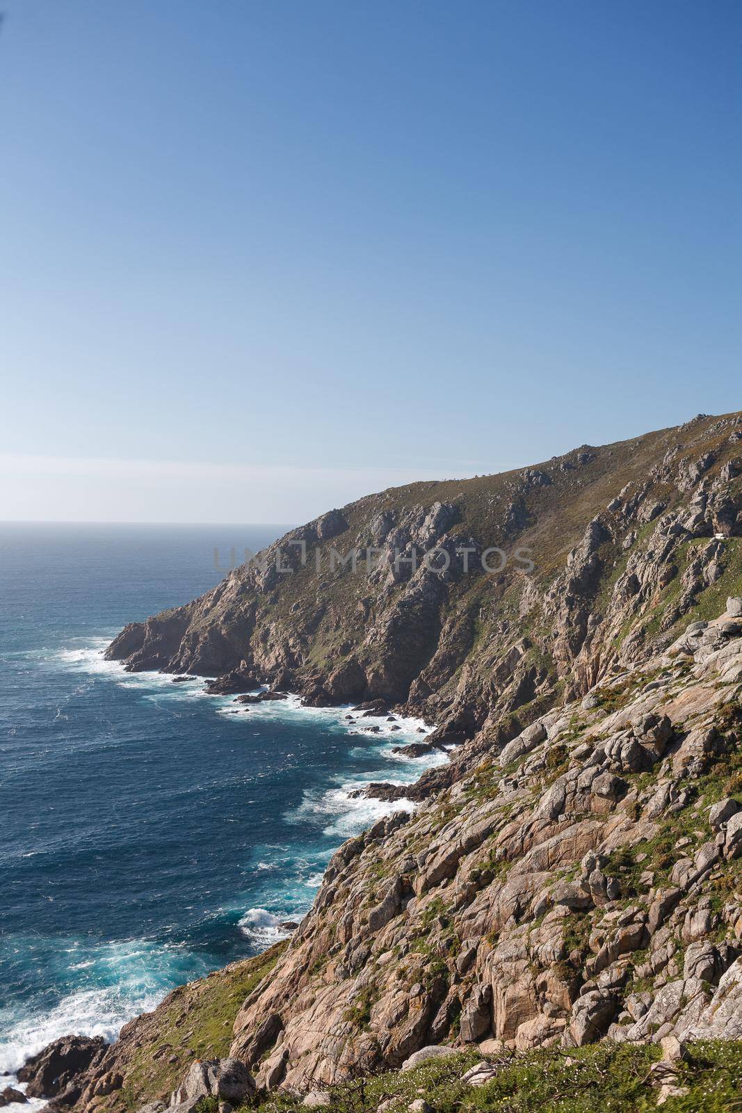 Beautiful landscape scenery of Cape Finisterre - View from Fisterra in Spain. Mountain ocean shore. Sea waves crash of rocky beach