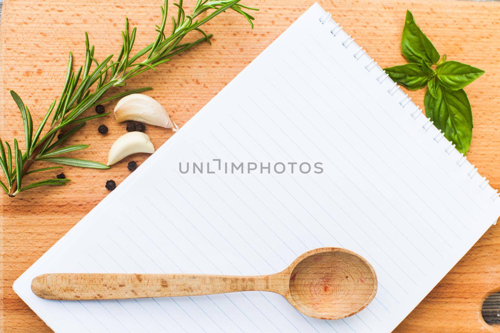 Recipe concept. Blank sheet of paper on a wooden board with spices