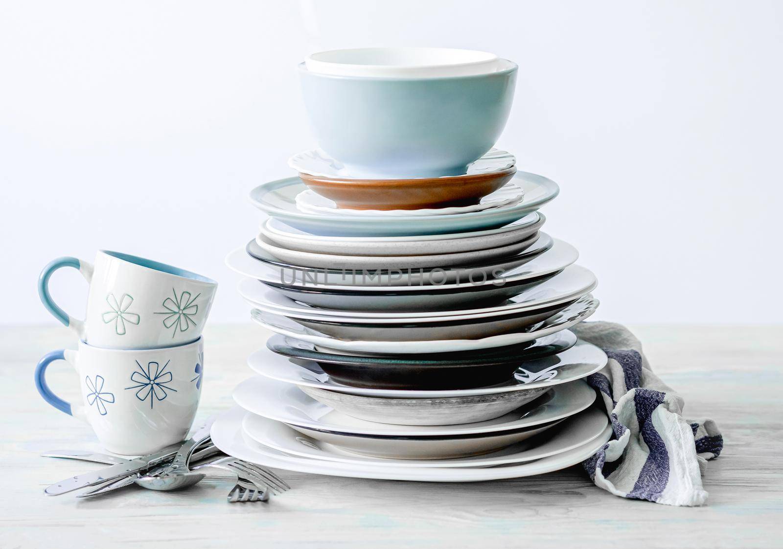 Clean porcelain cups and stack of plates