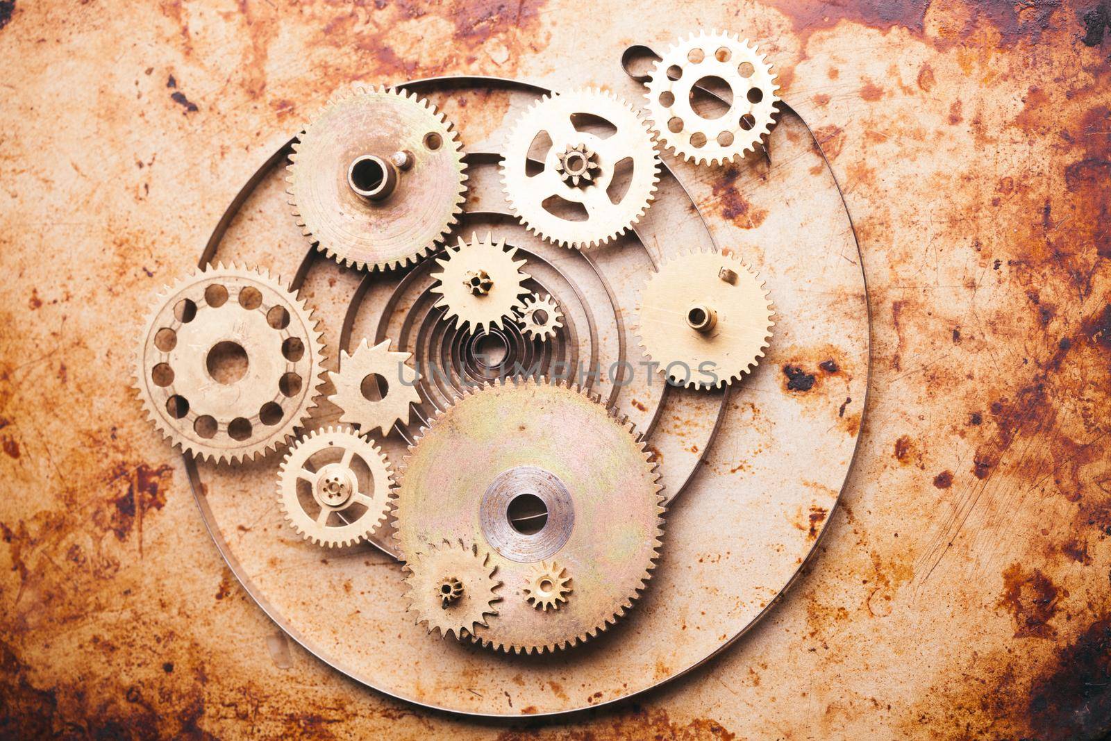 Steampunk background from mechanical clocks details over old metal background. Inside the clock, gears