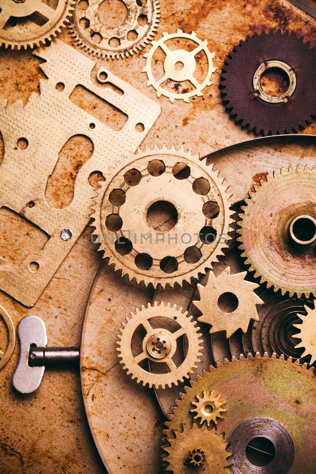 Steampunk background from mechanical clocks details over old metal background. Inside the clock, gears