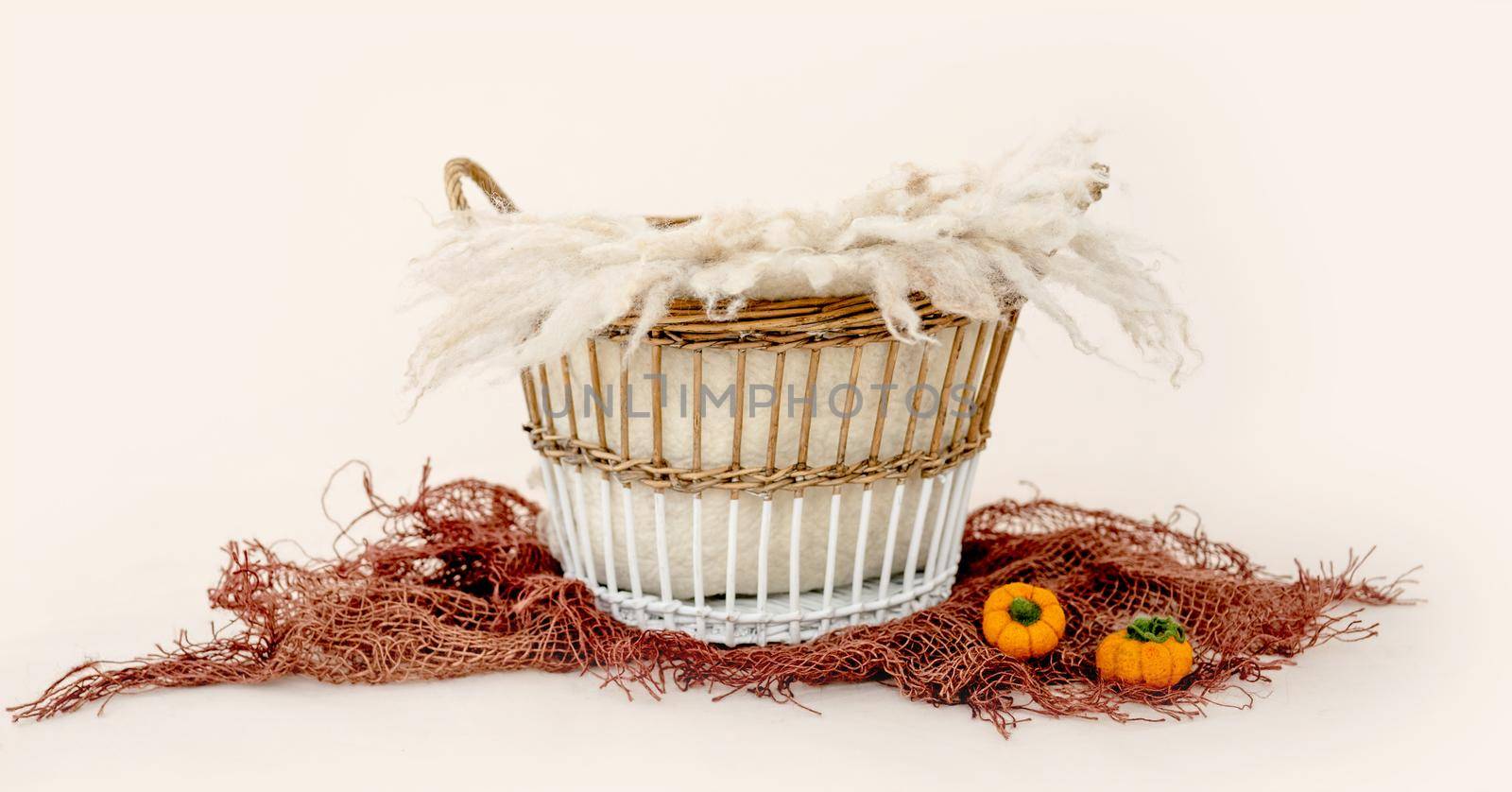 Decoration basket for newborn studio photoshoot in autumn. Tiny bed with pampkins toys for infant baby photos