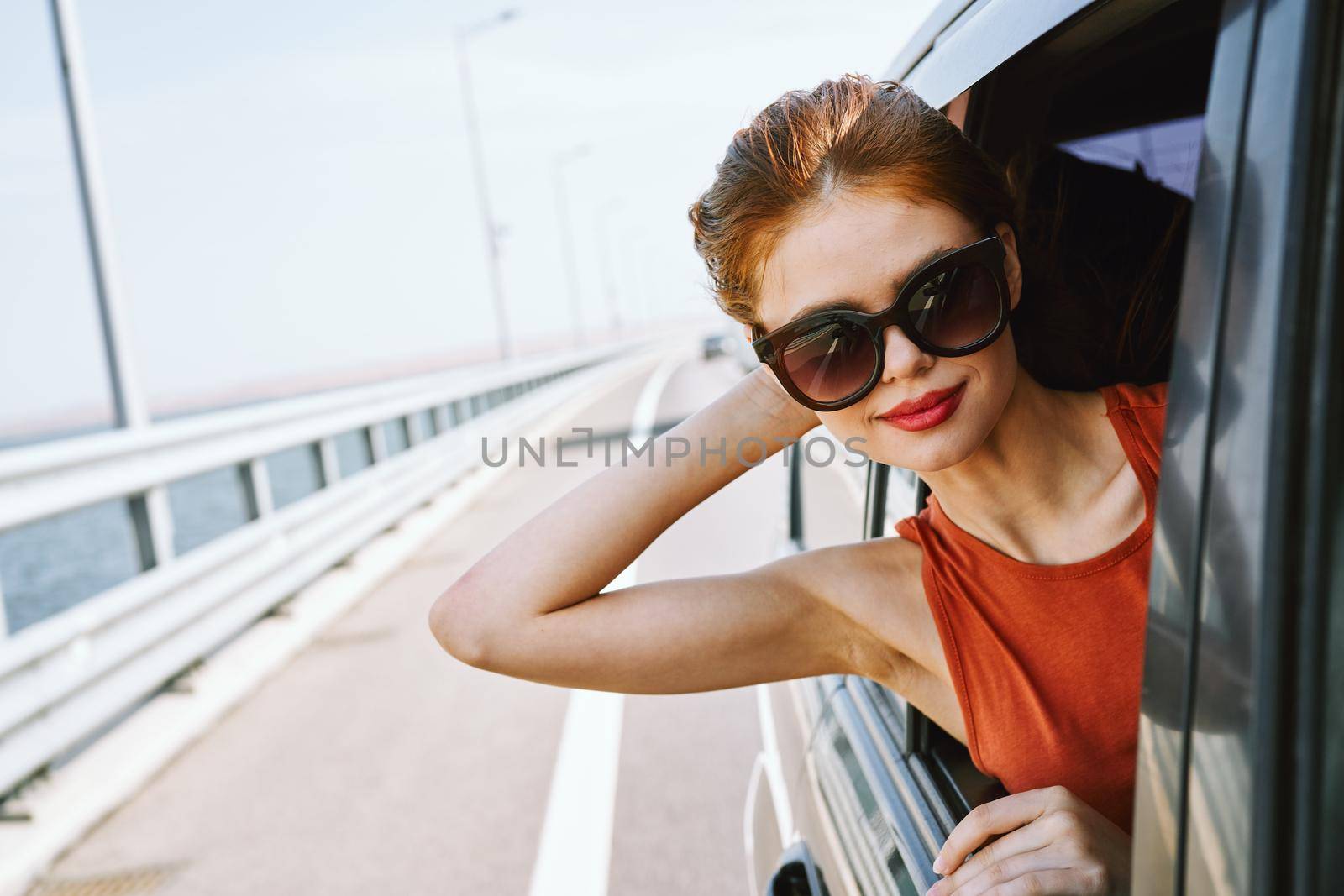 woman looking out of car window wearing sunglasses travel lifestyle. High quality photo