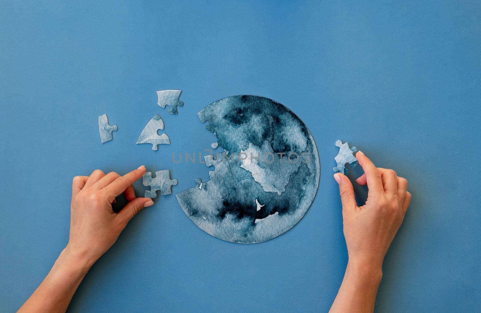 Hands collecting round jigsaw puzzle by tan4ikk1