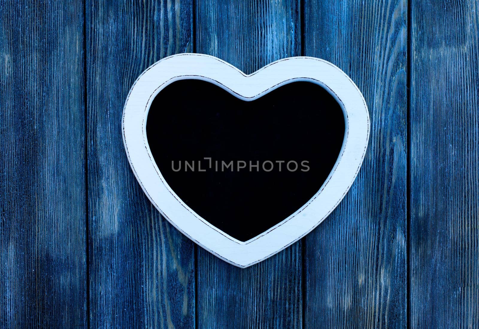 Heart shape chalkboard on the blue wooden wall