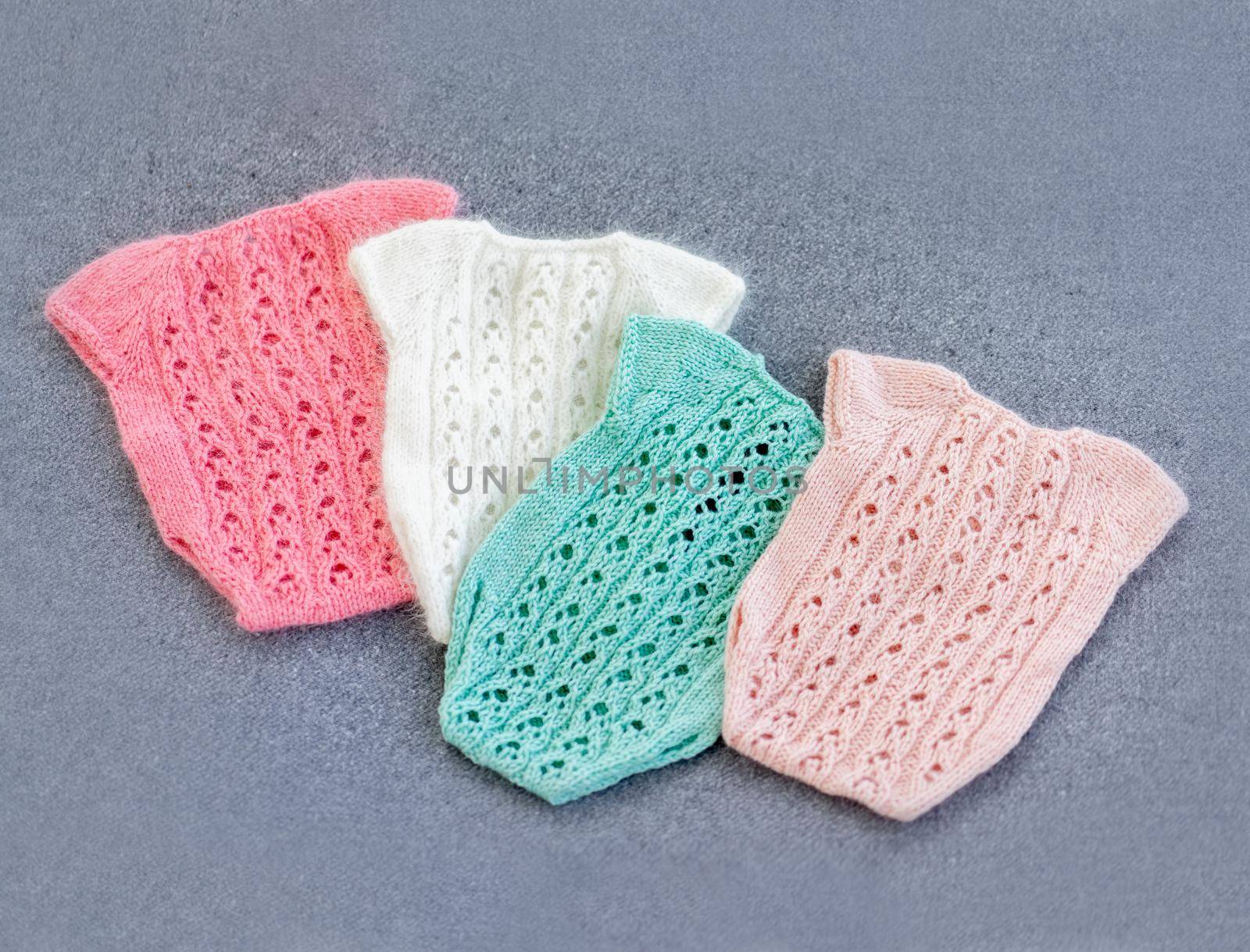 knitted newborn baby clothes composed on the woolen background