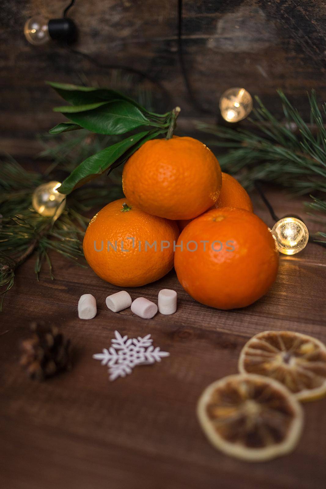 Christmas still life with fresh mandarines, marshmallows and garland on wooden background. Nature New Year concept in instagram style.