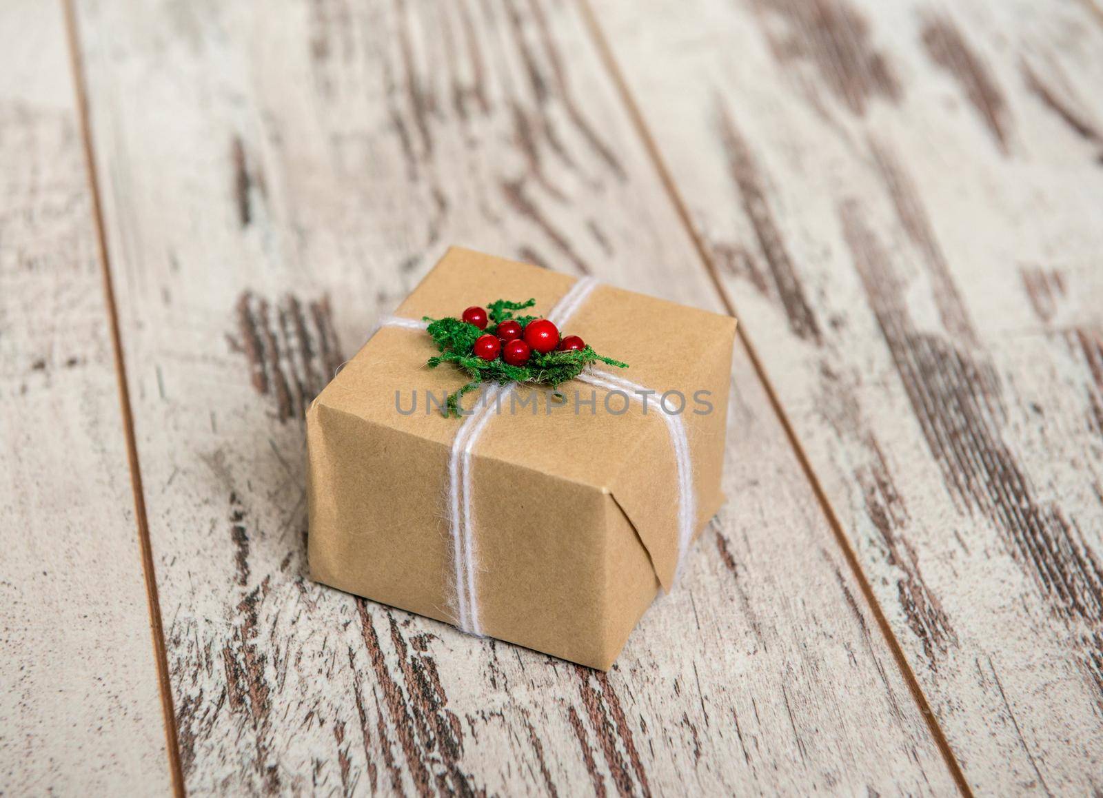 christmas present in wrap on wooden background