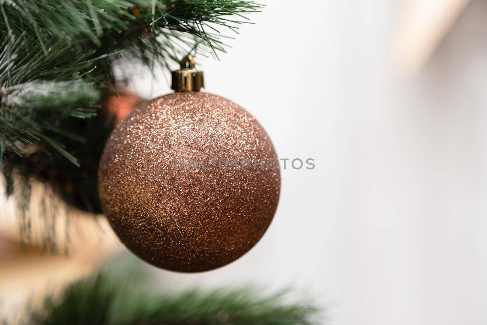 Christmas ball hanging on a christmas tree branch with copy space on white background.
