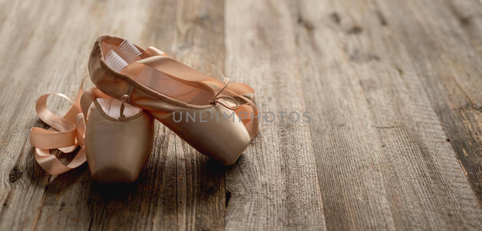 Pointe shoes with ribbons on wooden background by tan4ikk1