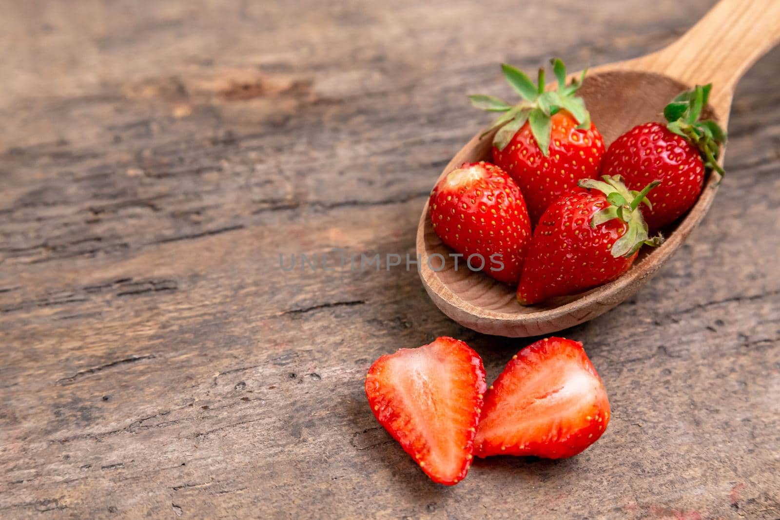 Sweet Strawberry, natural fruits. Strawberries with wooden spoon on wooden table. Food background from freshly harvested strawberries