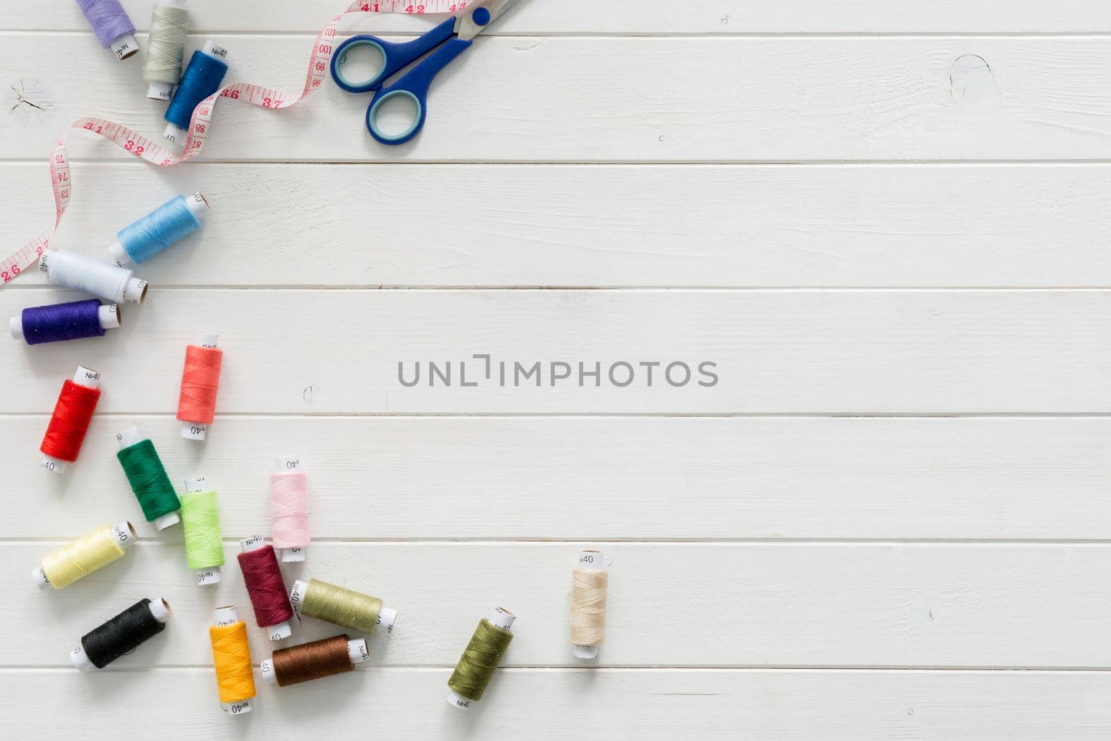 white wooden planks background with colorful thread skeins by tan4ikk1