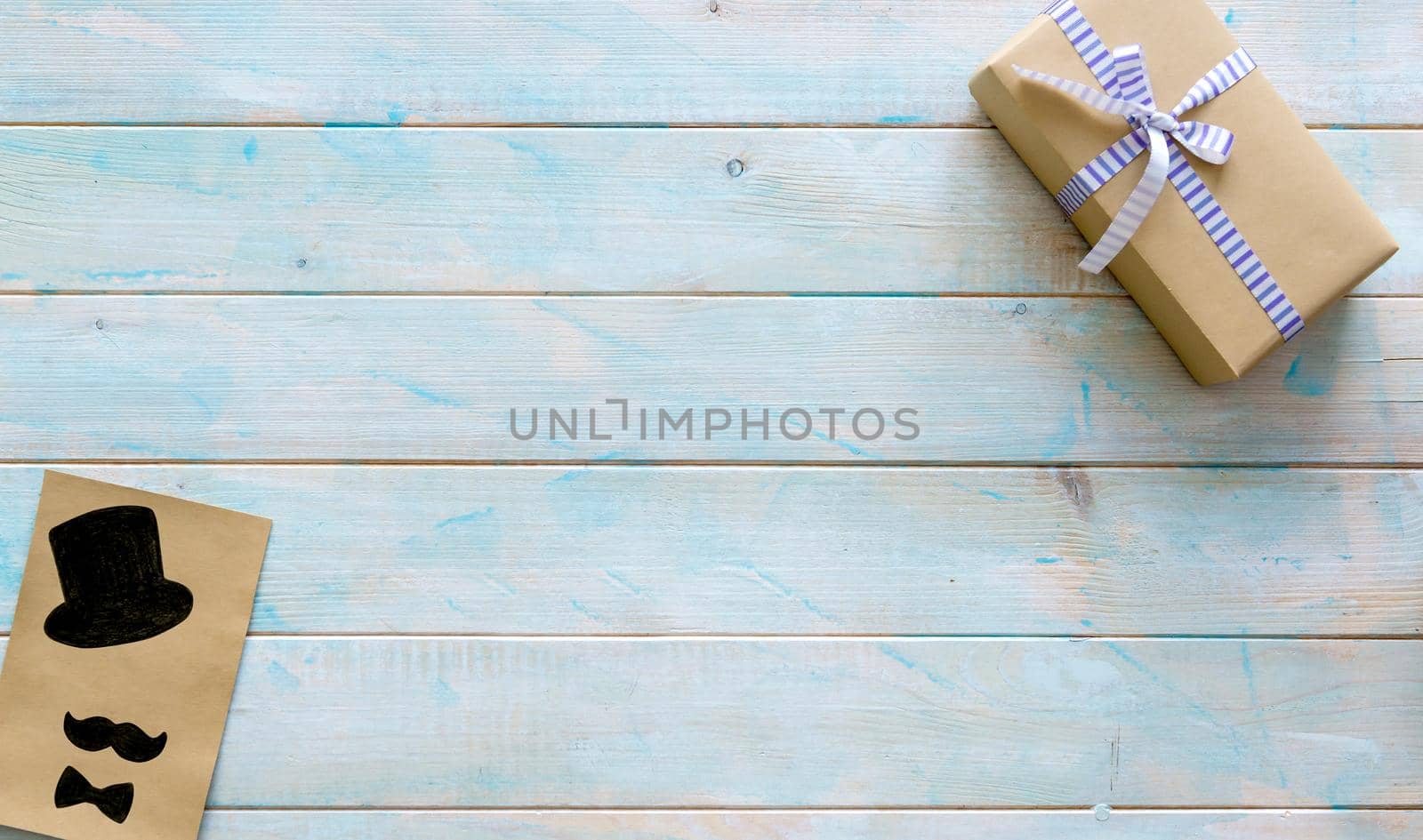 Lovely small present box with handmade greeting card on turquoise wooden background. Special gift for father's day. Happy father's day concept. Top view, copyspace, space for text