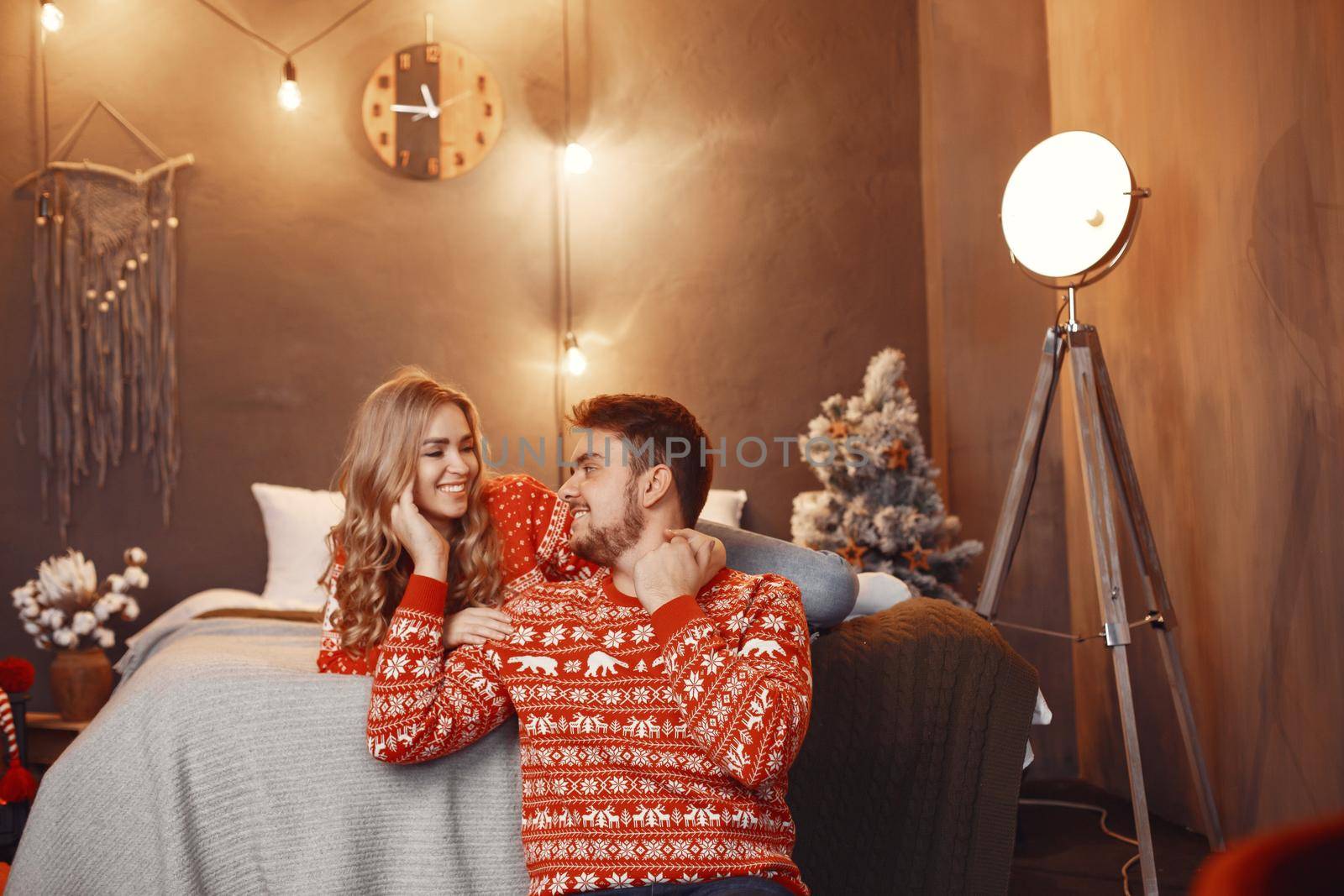 People in a Christman decorations. Man and woman in a red sweater. Family at home.