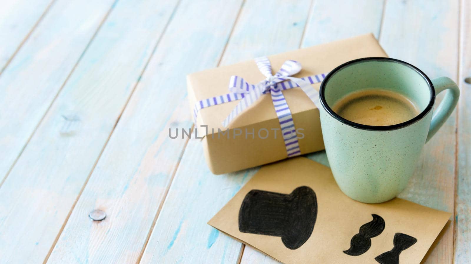 Happy Father's day greeting with cup of tasty coffee and gift box on rustic wooden background. Happy father's day concept. Greetings for father's day