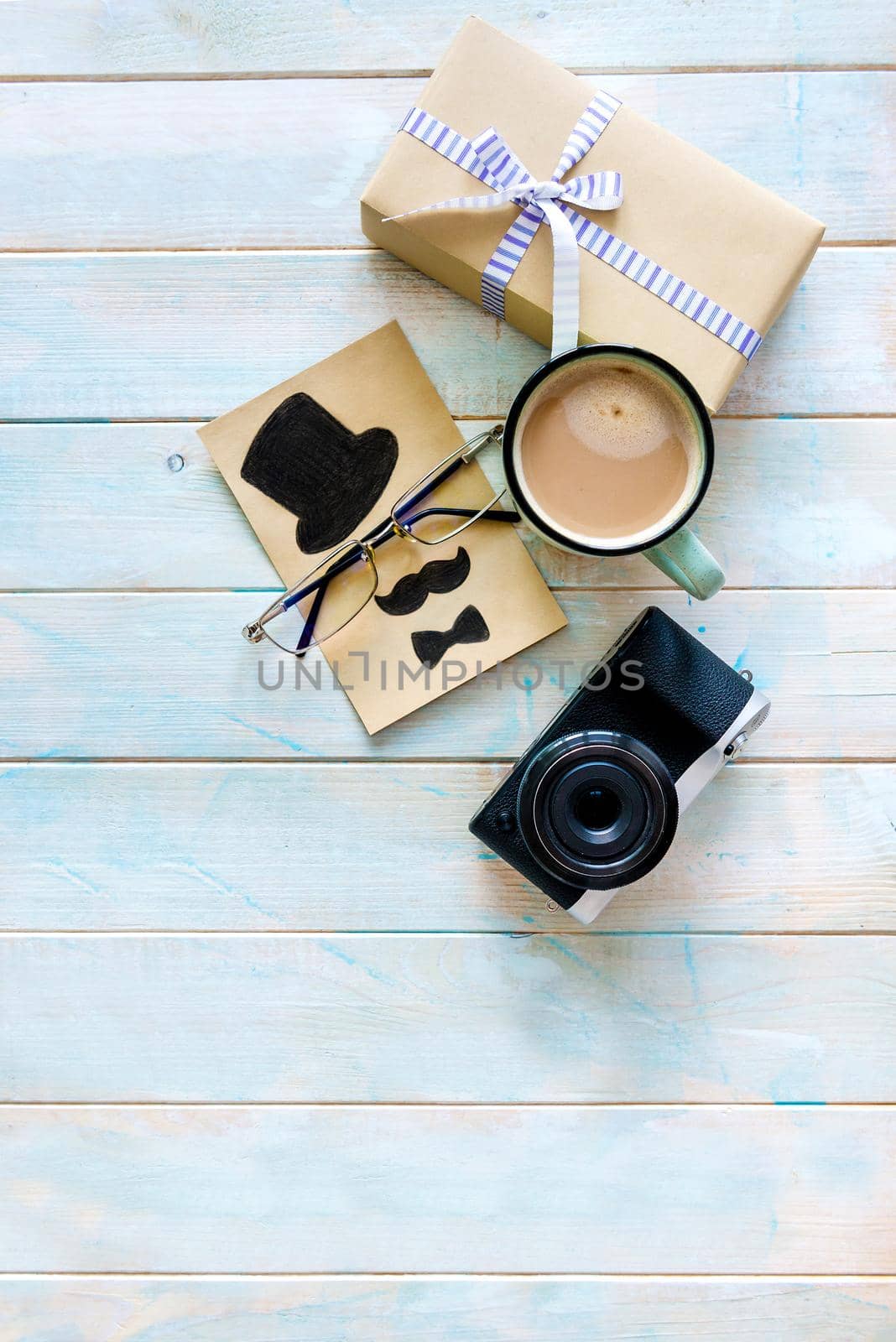 Gift box composition with digital camera, cup of coffee and creative greeting card on painted wooden background. Happy father's day concept. Gifts for man. Copyspace