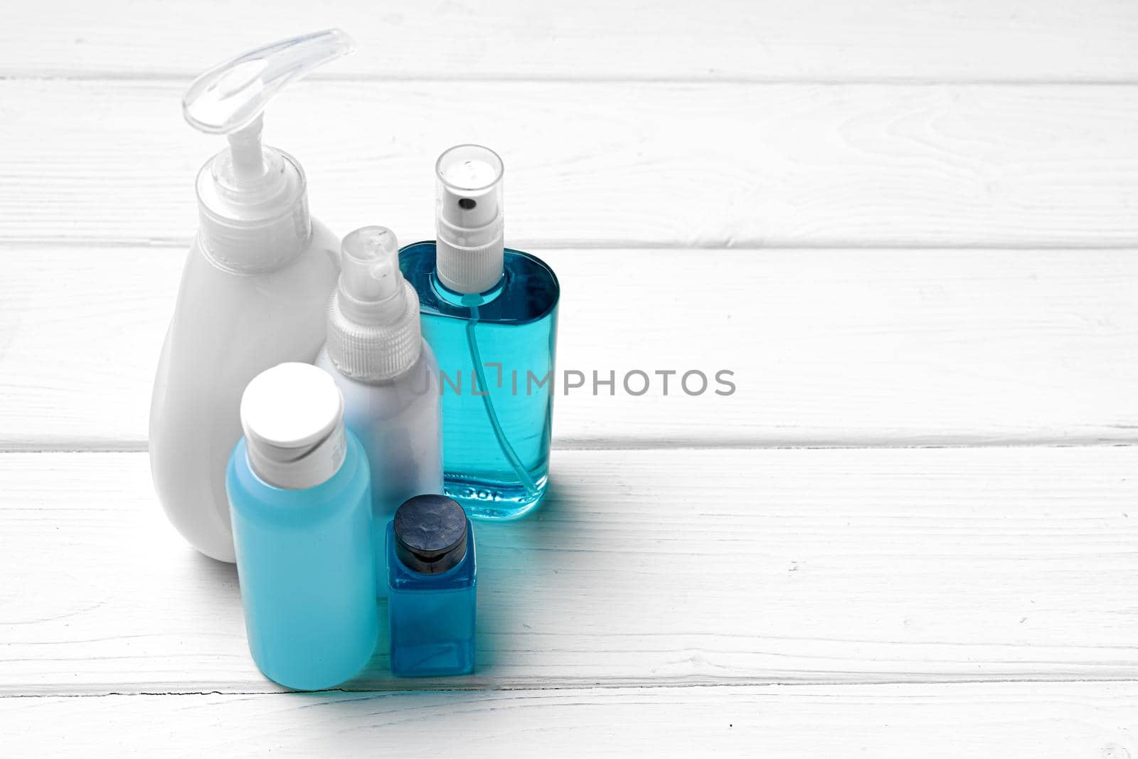 Hand sanitizer bottles on white wooden table close up