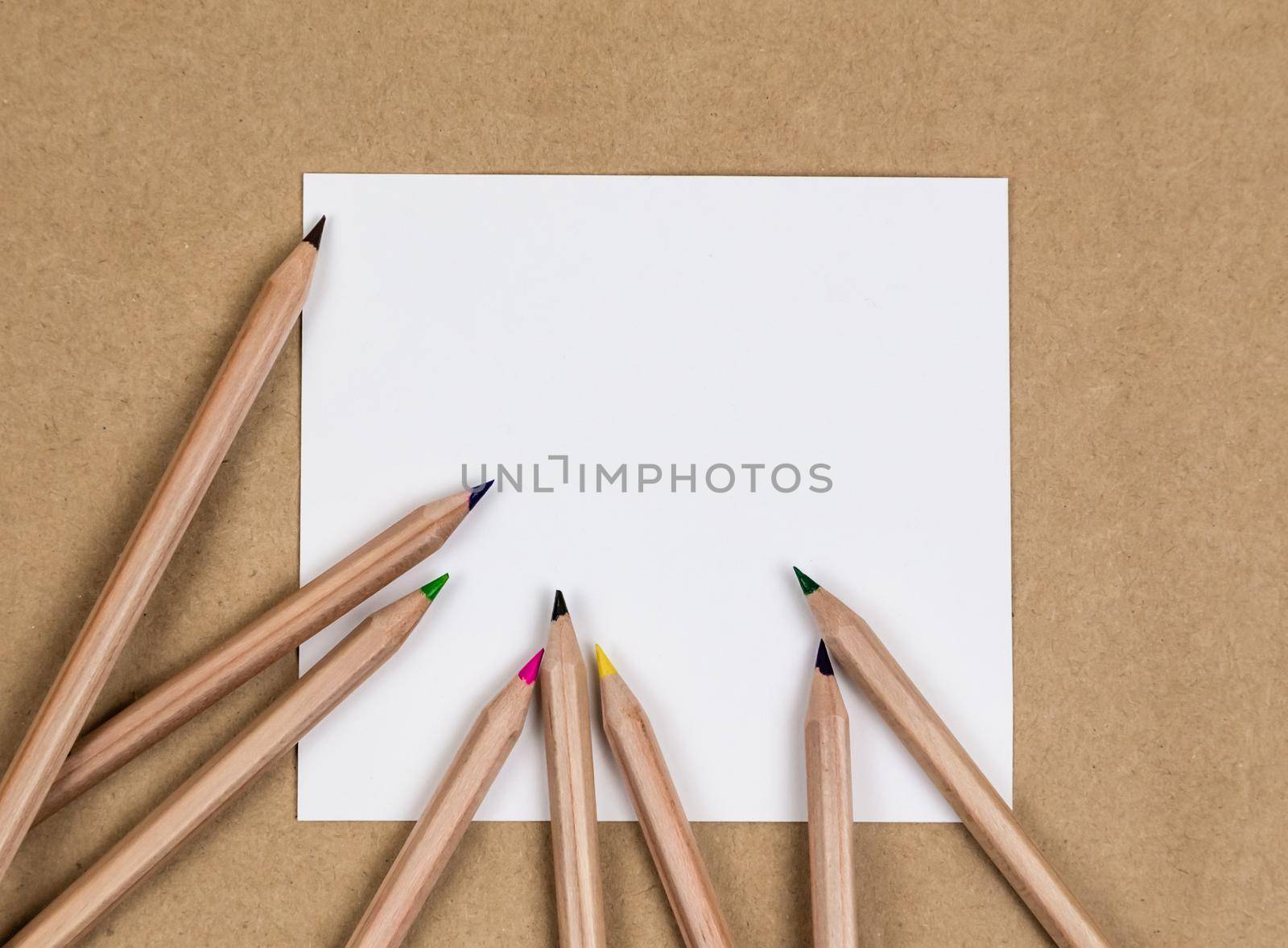 notebook blank page colorful pencil mock-up composition. Back to school concept with stationery office supplies on a brown craft paper background copy space.