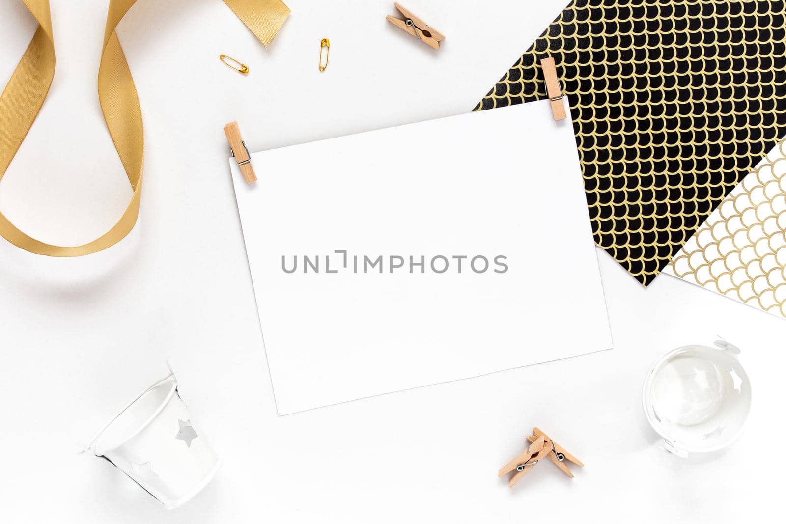 Top view on Beautiful greeting card idea with area for your text with golden ribbon, wooden clothespins copyspace, topview, mockup, flatlay.