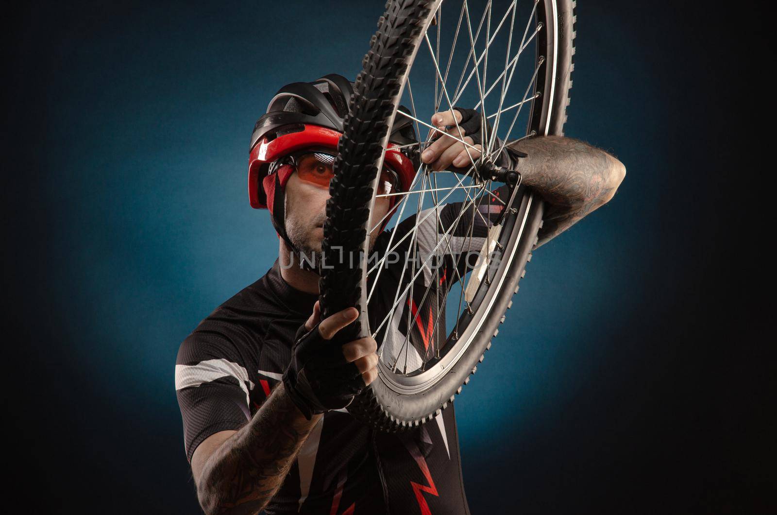 a guy-cyclist in a Bicycle helmet with a Bicycle wheel