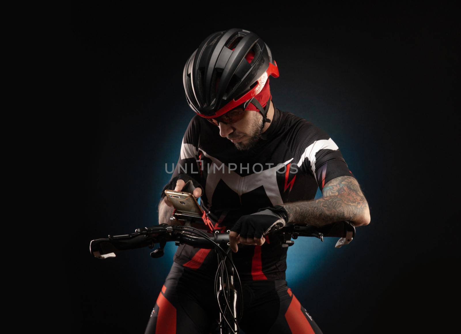 guy-cyclist in a Bicycle helmet looks at the phone Navigator by Rotozey