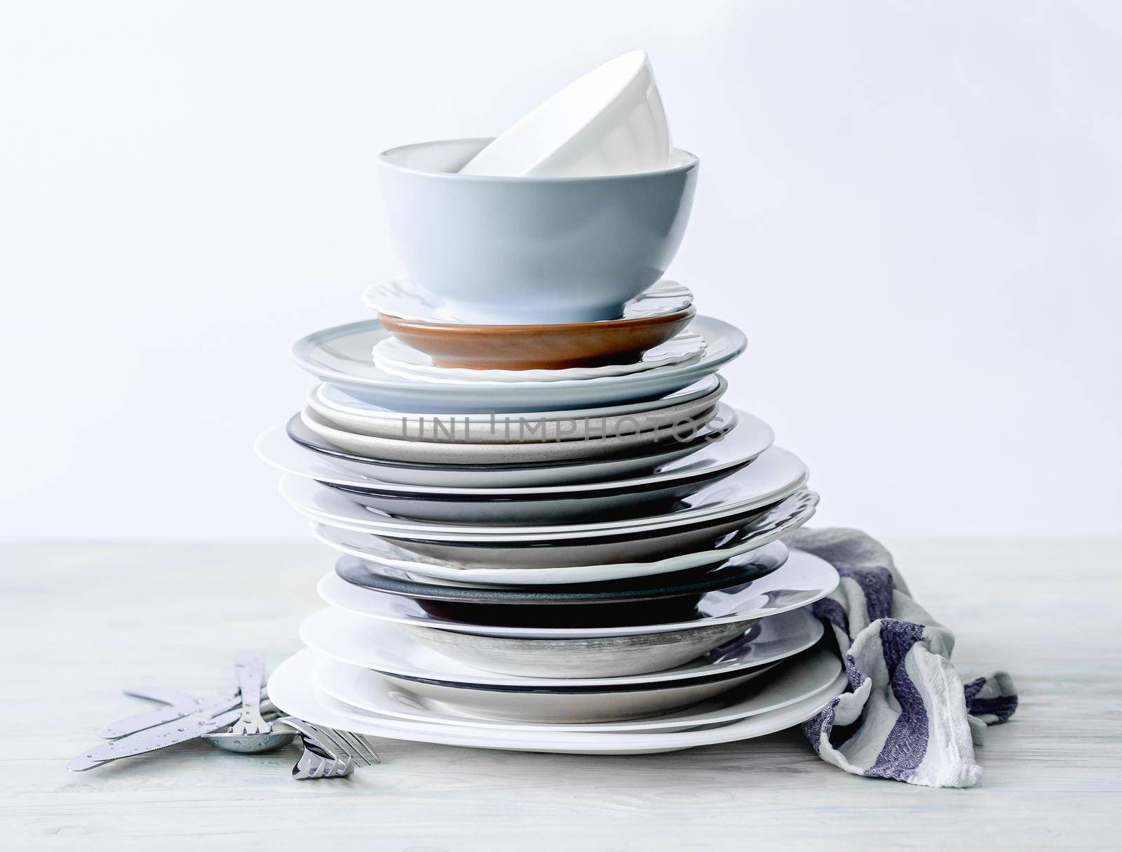 Stack of different porcelain plates on white table