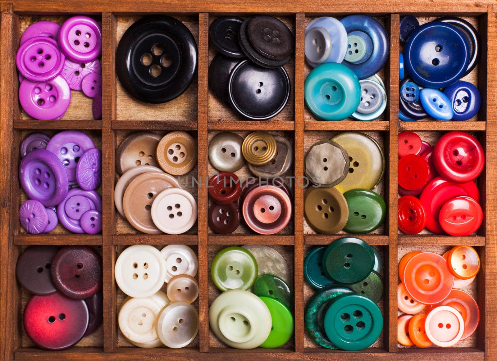 Colorful buttons in a wooden box for design