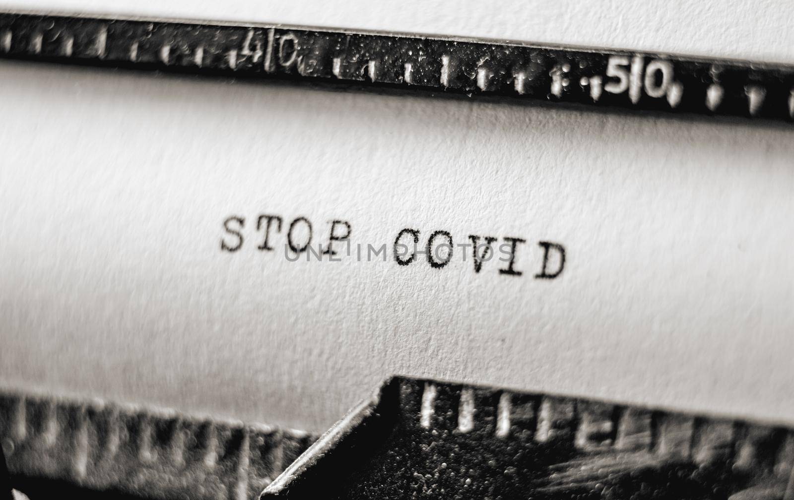 Actual text Stop Covid printed on retro typewriter. Vintage information message using typescript