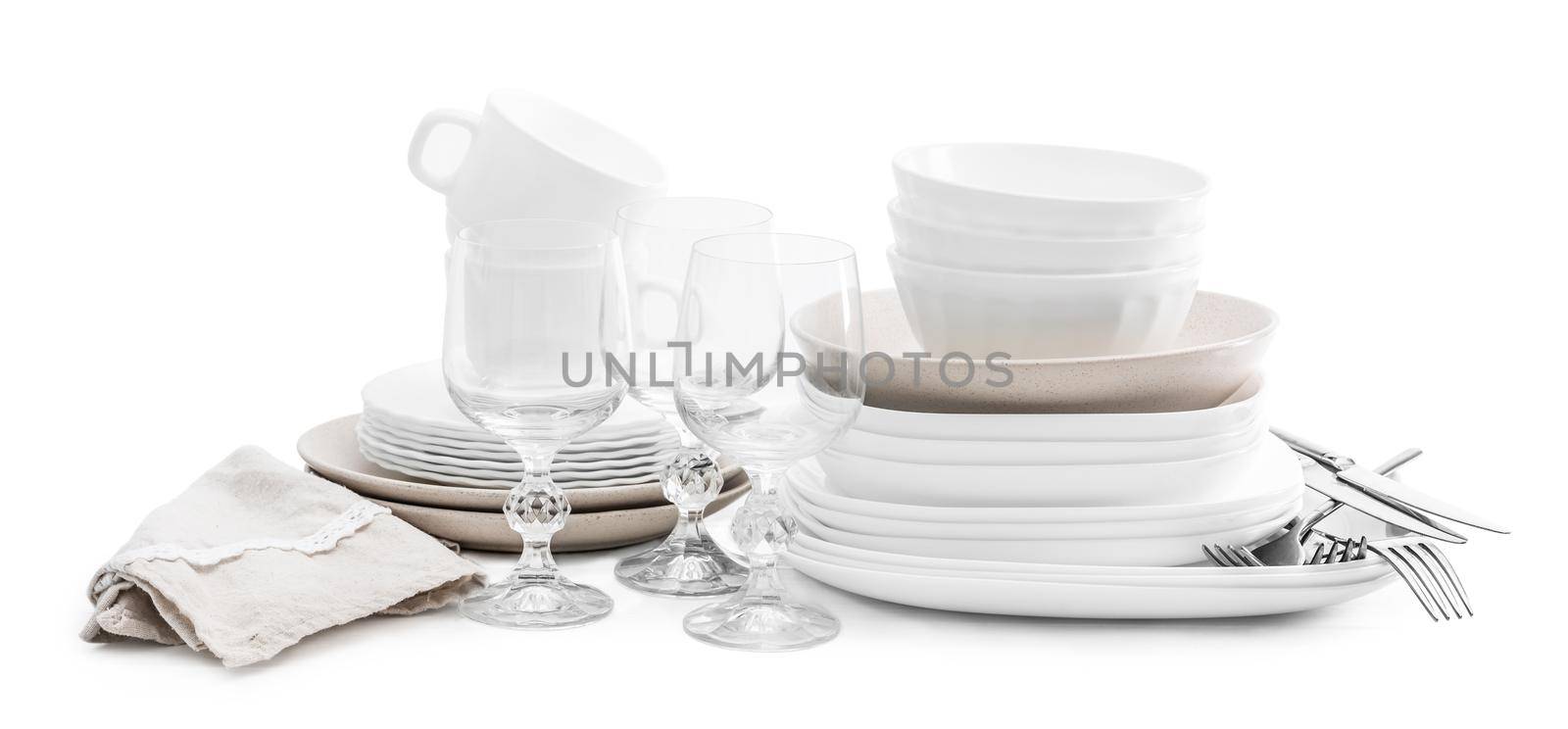 Set of white and beuge ceramic dishes and crystal glasses isolated on white background
