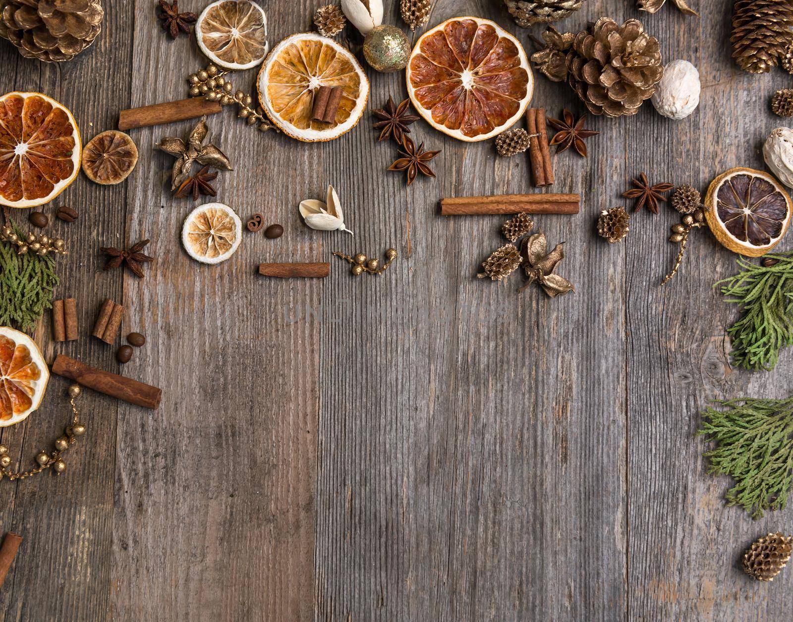 Christmas decorations on an old wooden background with cinnamon and dried orange slices. Space for text