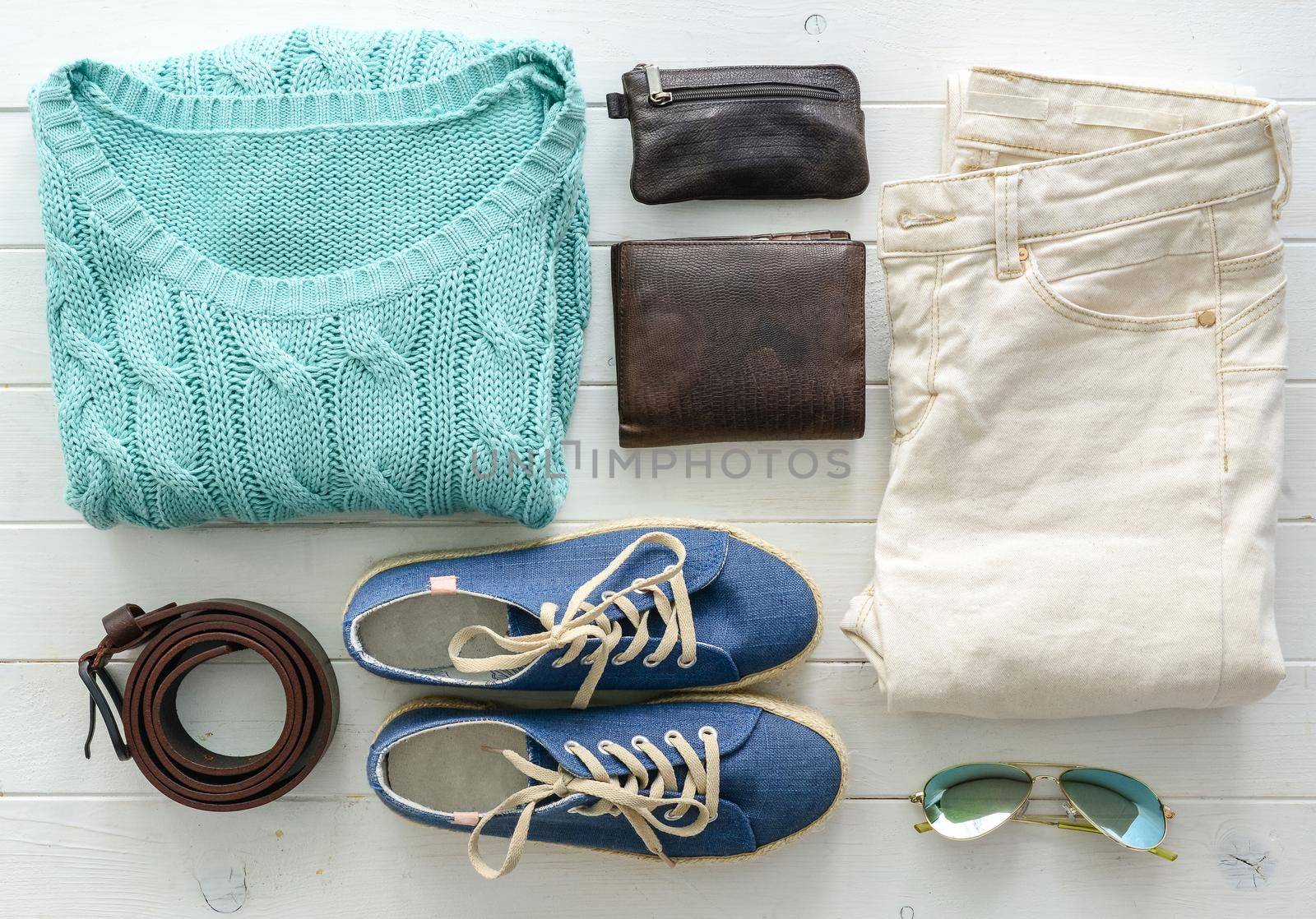 carefully folded woman casual closes and accessories on wooden table top view