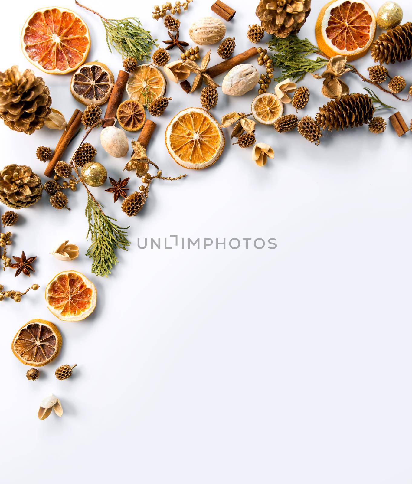 christmas decorations background with space for text of dried oranges, cinnamon and cones. white background