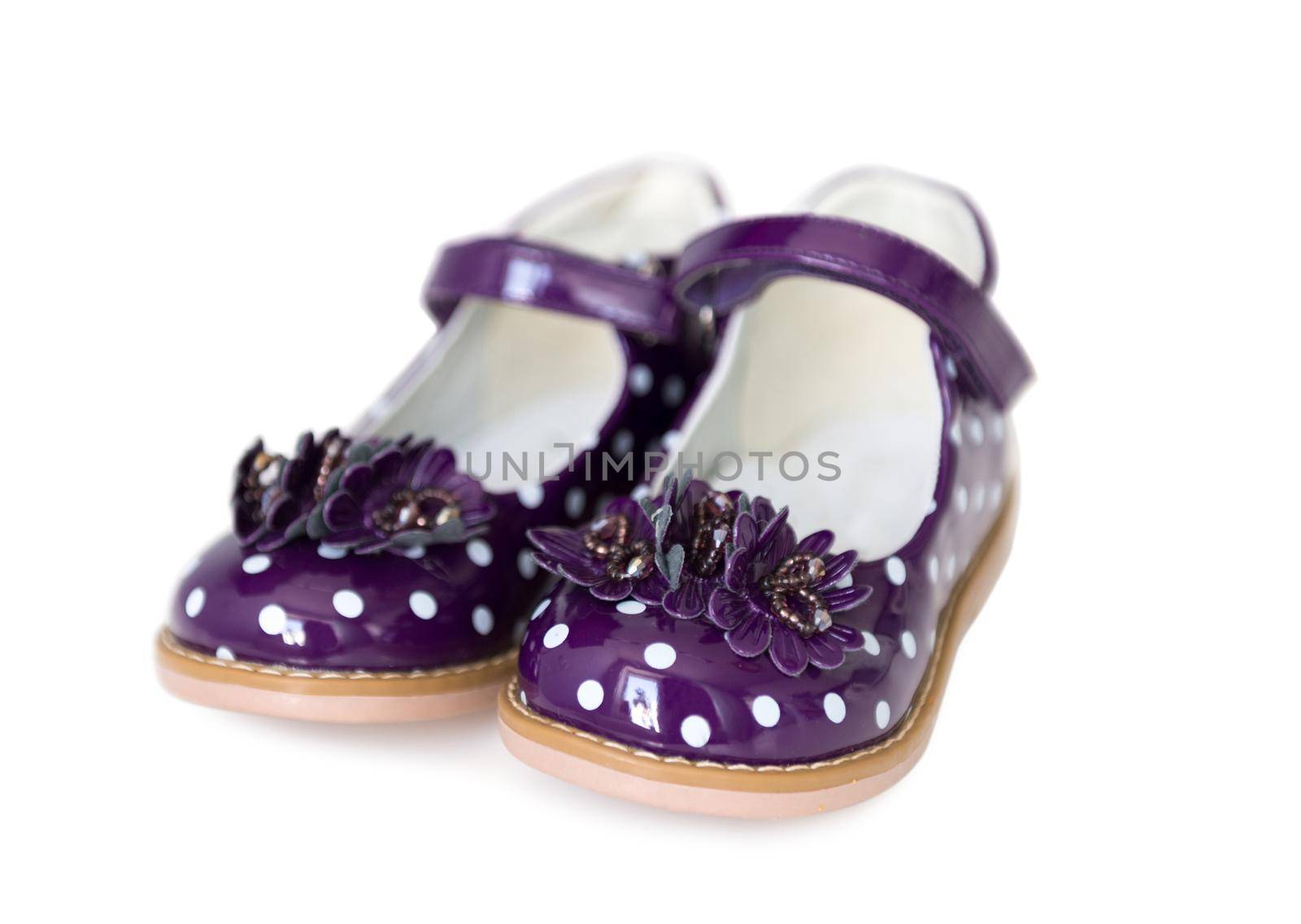nice spotted purple patent leather shoes for little girls, isolated on white background
