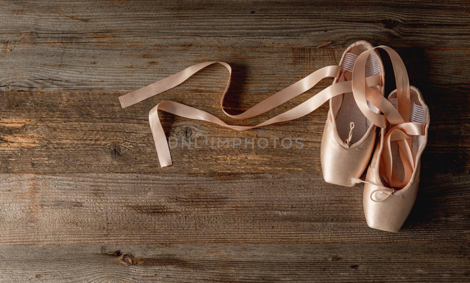 Pointe shoes with ribbons on wooden background by tan4ikk1