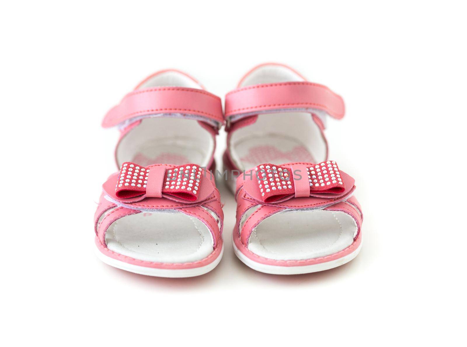 tiny pink sandals with bow isolated on white background