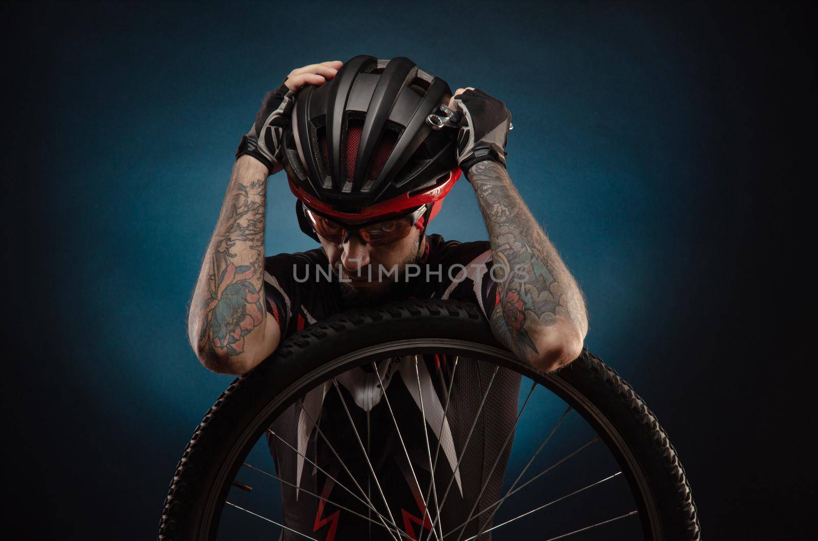 a guy-cyclist in a Bicycle helmet with a Bicycle wheel