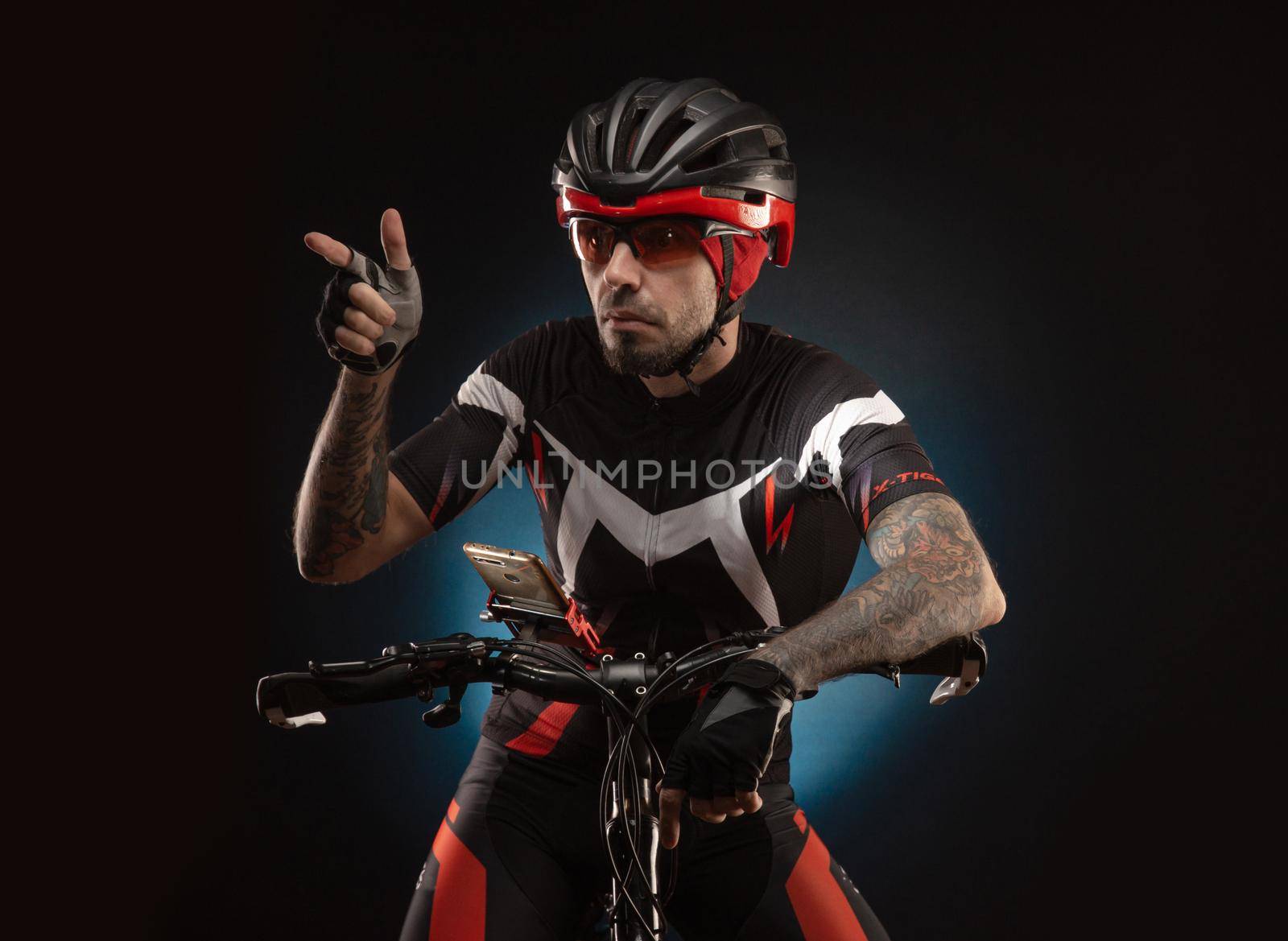 guy cyclist in a Bicycle helmet looks at the phone Navigator