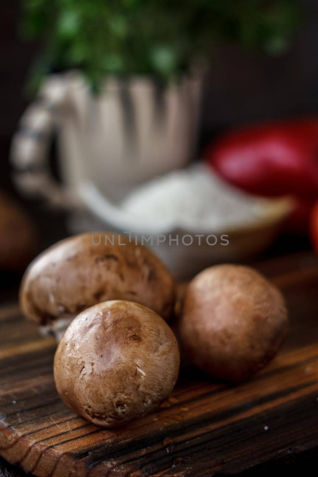 Raw mushrooms on wooden board. Three mushrooms on kitchen