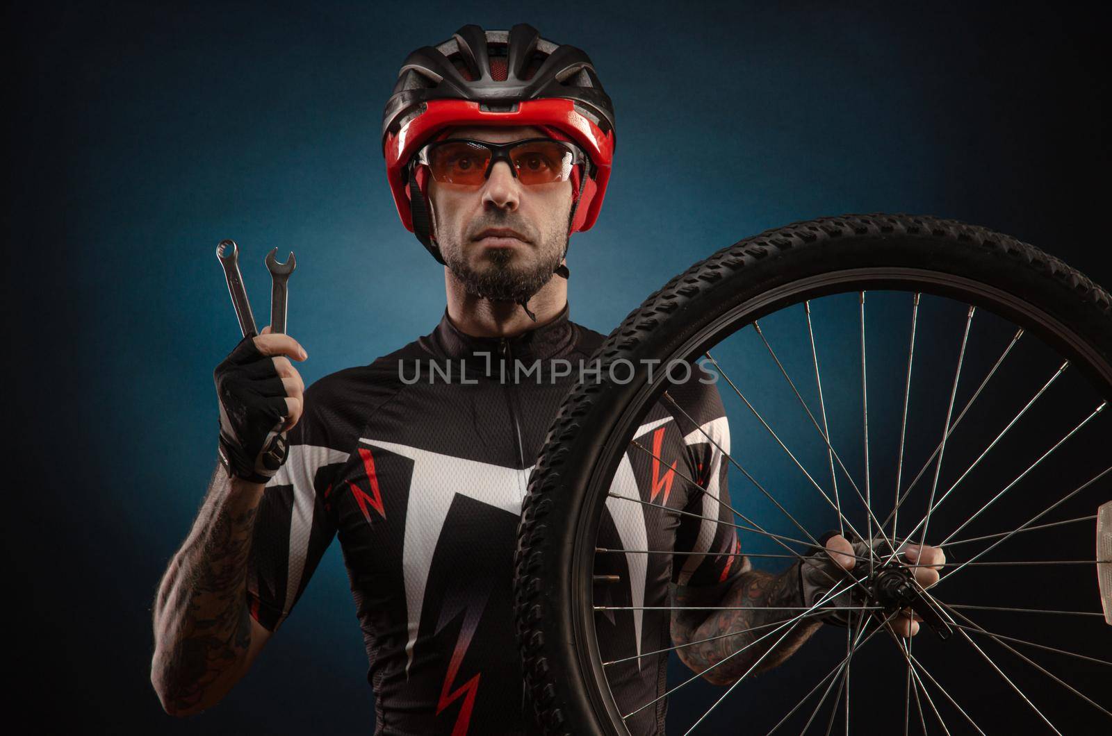 a guy-cyclist in a Bicycle helmet with a Bicycle wheel