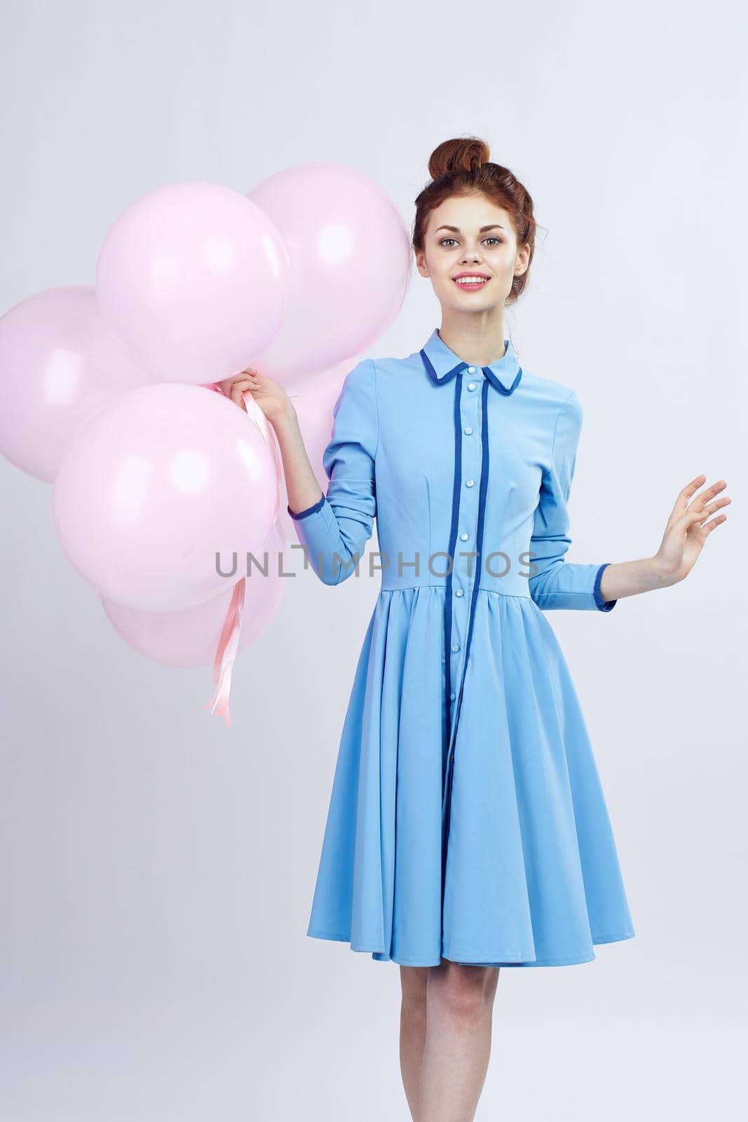 cheerful woman in a blue dress pink balloons holiday birthday. High quality photo