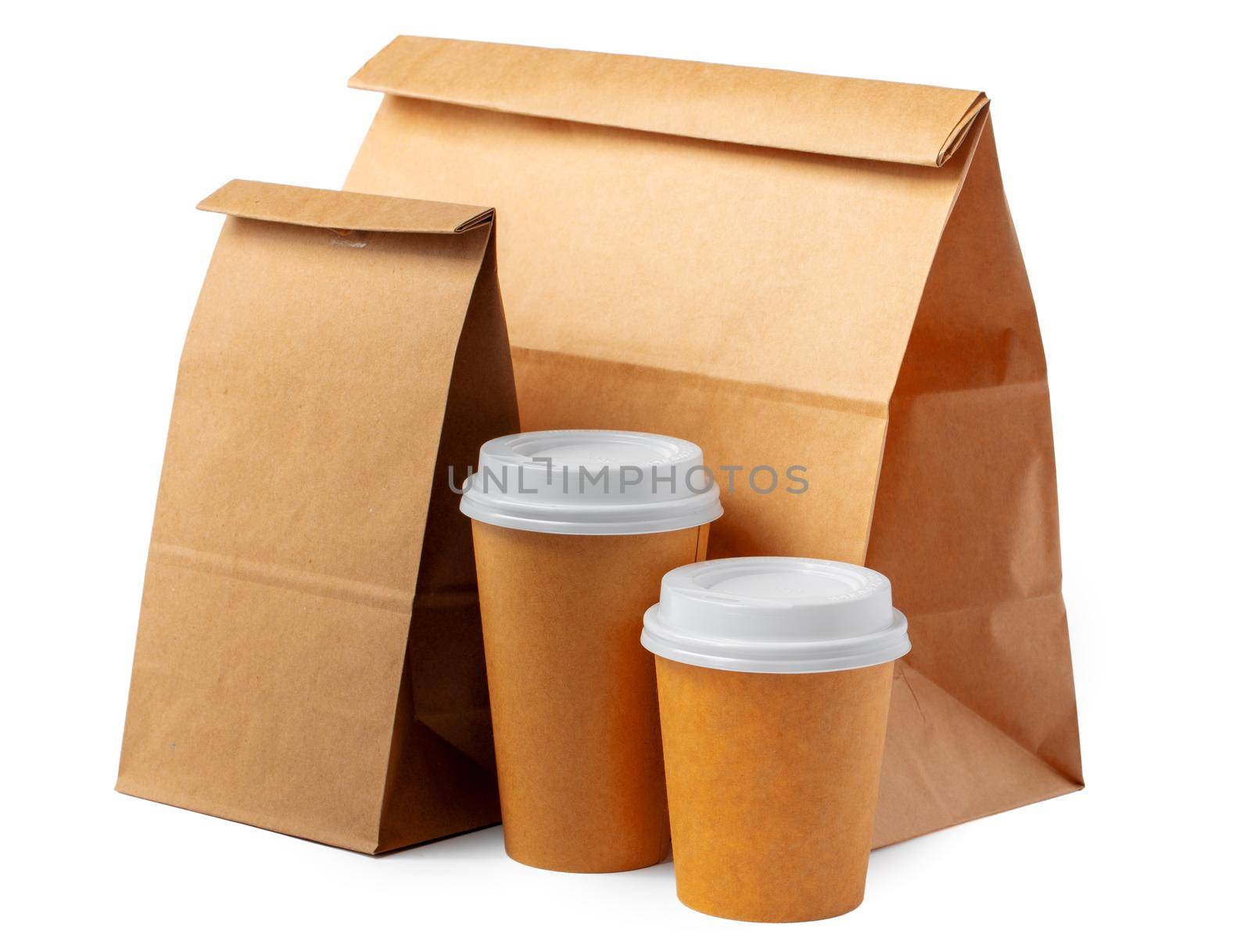 Craft paper bag and coffee to go cups on white background close up