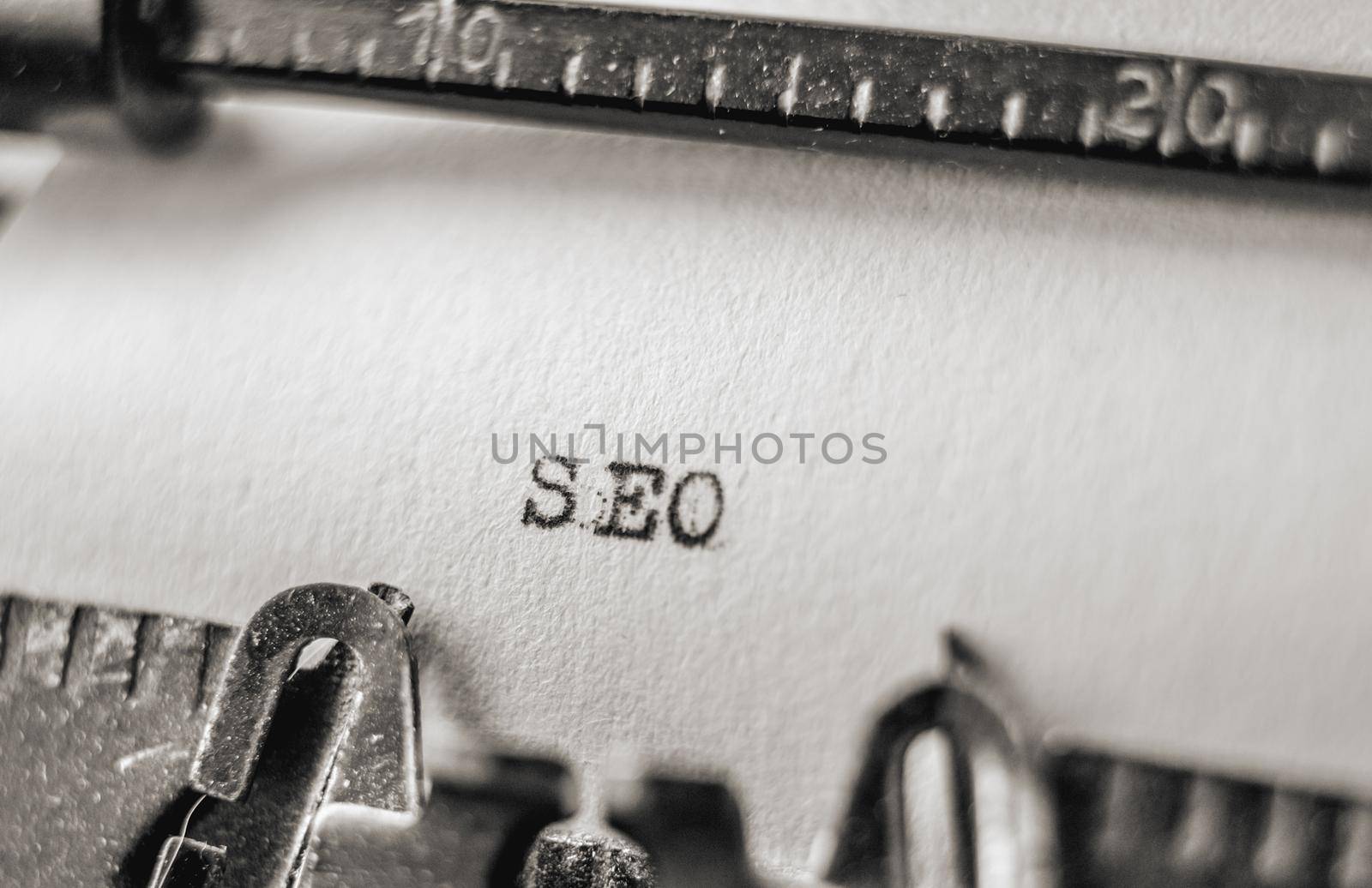 Word SEO printed on retro vintage old typewriter using black inks and white paper