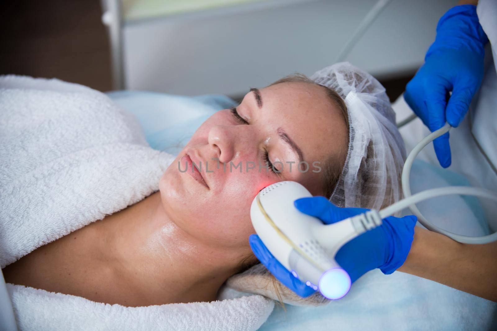 Cosmetology clinic. Pore cleansing procedure. A woman cosmetologist working with a tool. Close up