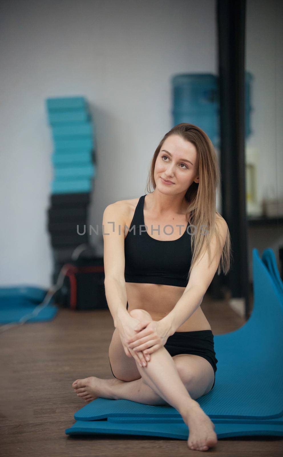 Beautiful young blonde girl in yoga class posing. Healthy lifestyle in fitness club. Stretching. Portrait