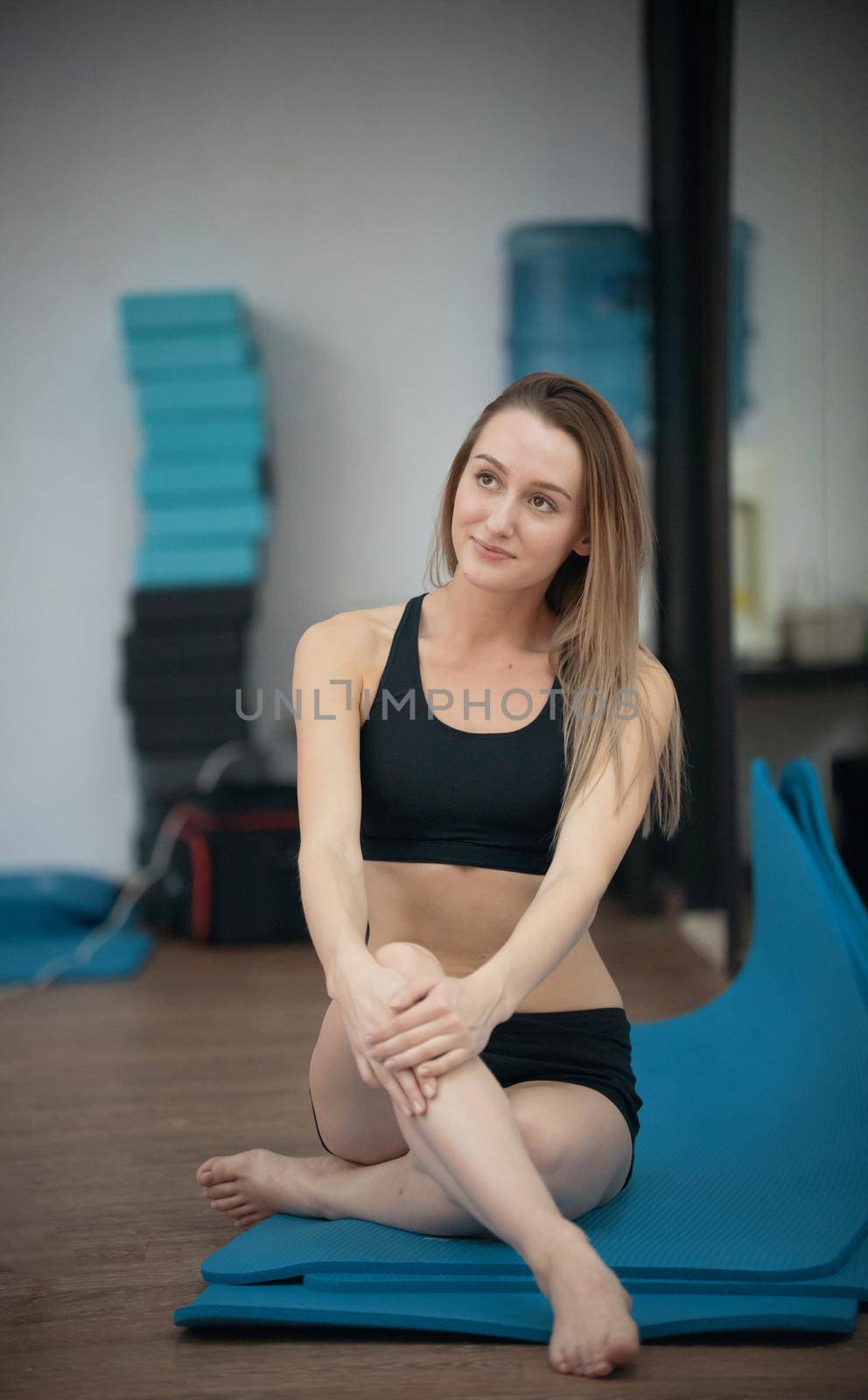 Beautiful young blonde woman in yoga class posing. Healthy lifestyle in fitness club. Stretching by Studia72