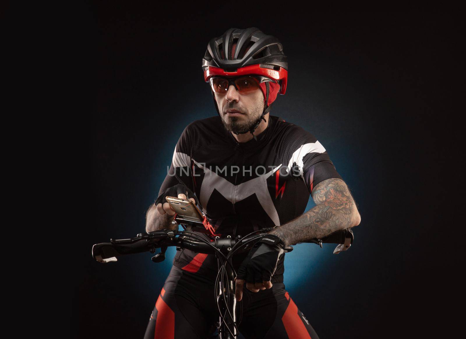 guy cyclist in a Bicycle helmet looks at the phone Navigator