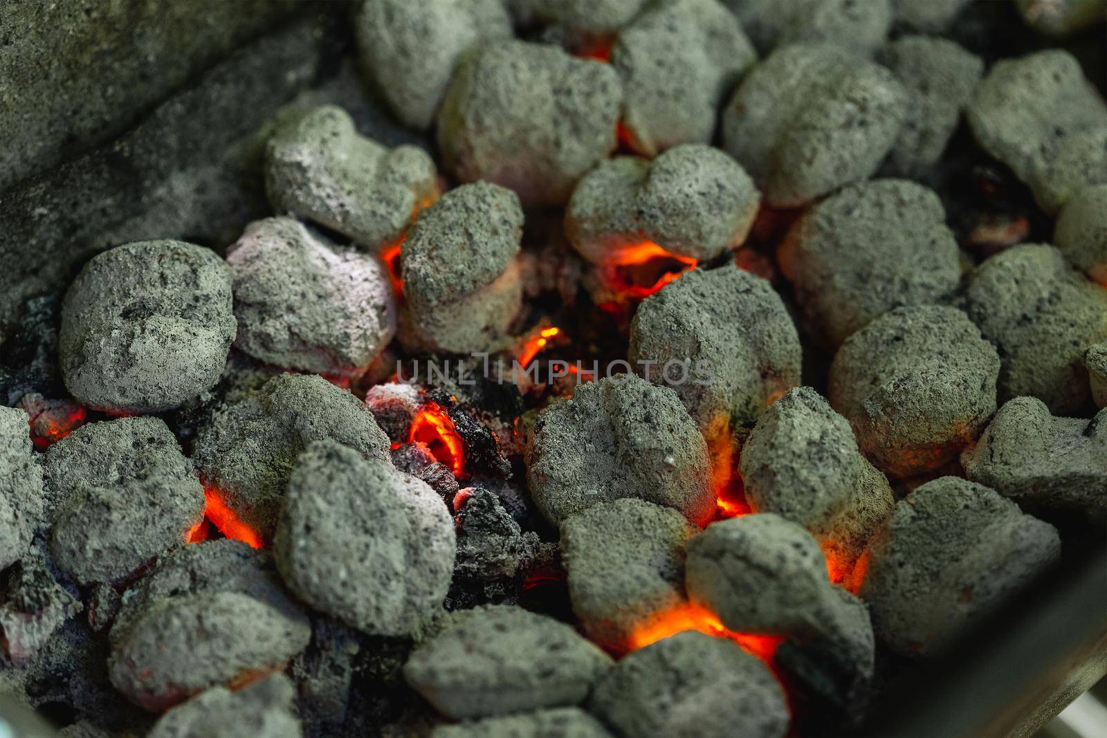 Burnt charcoal bricks ready to cook, summer barbecue. Selective focus