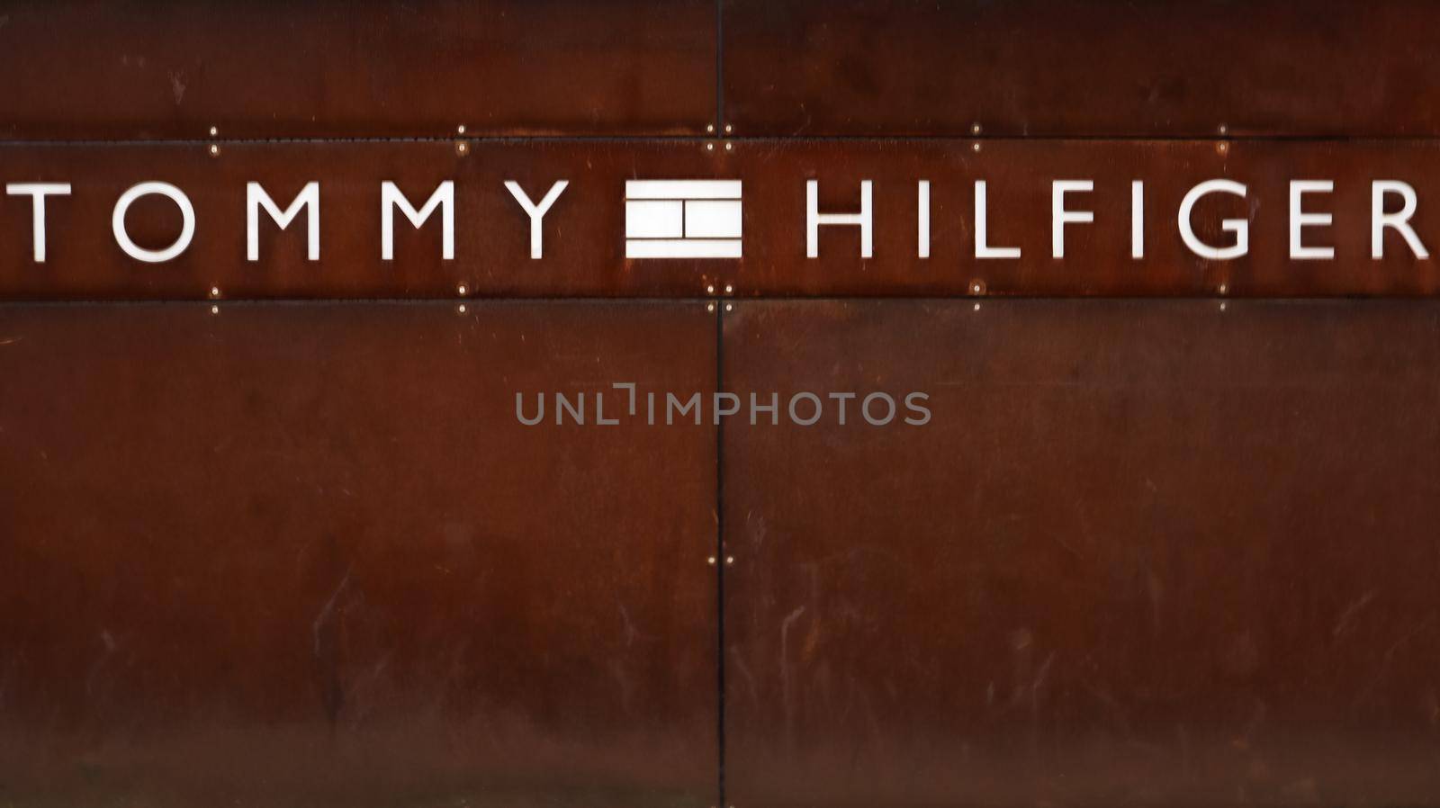 Germany, Dusseldorf - February 20, 2020. logo of the American brand Tommy Hilfiger. A sign at the entrance to the store on a wall of rusty metal. Copy space. Editorial photo