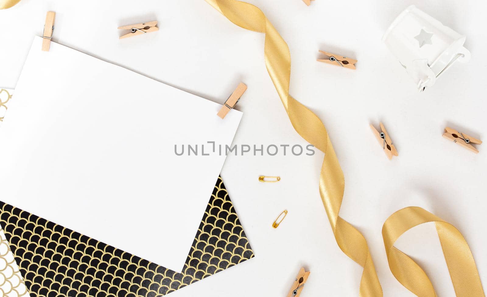 Top view on Beautiful greeting card idea with area for your text with golden ribbon, wooden clothespins copyspace, topview, mockup, flatlay.