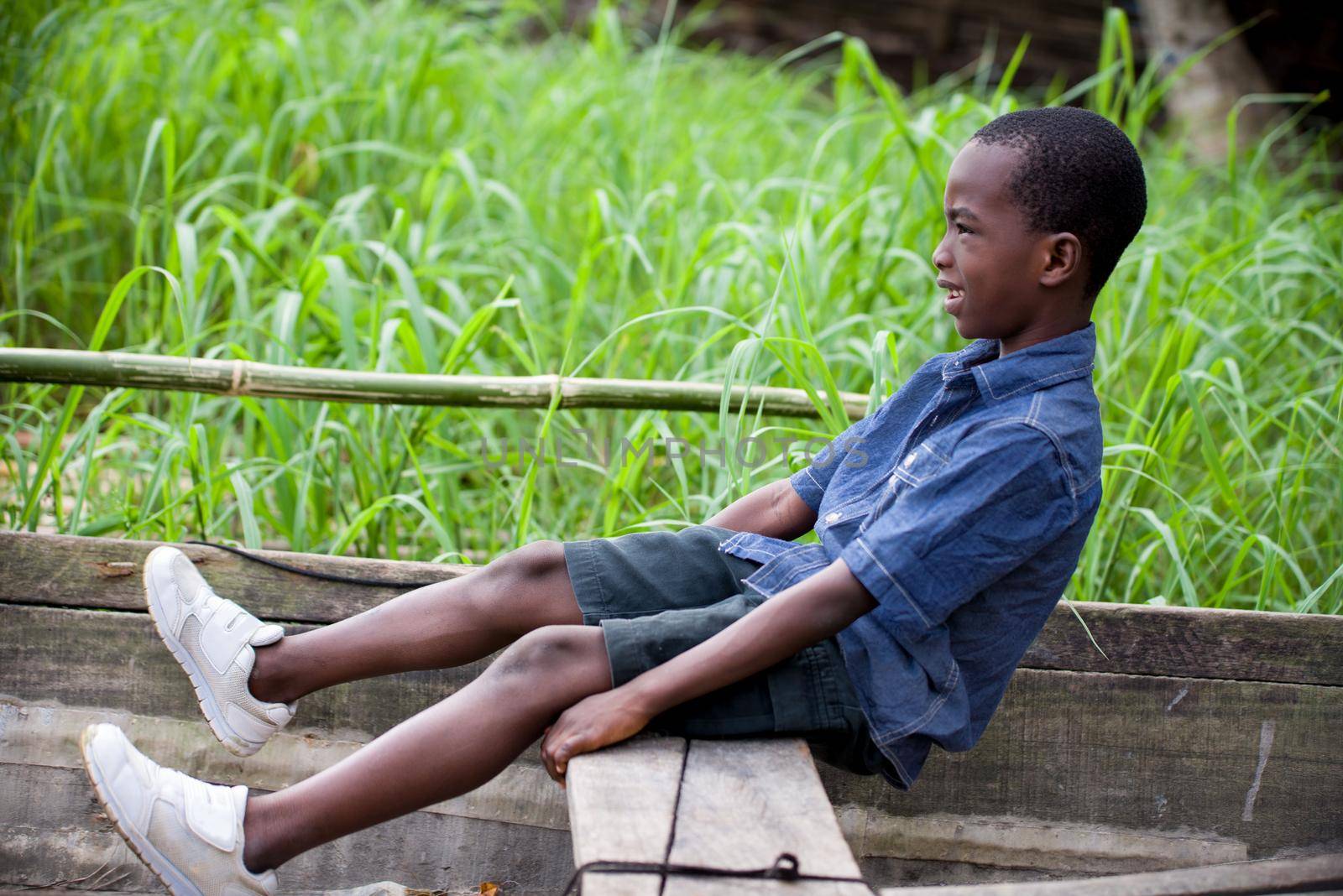 happy little boy sitting and playing on a dugout